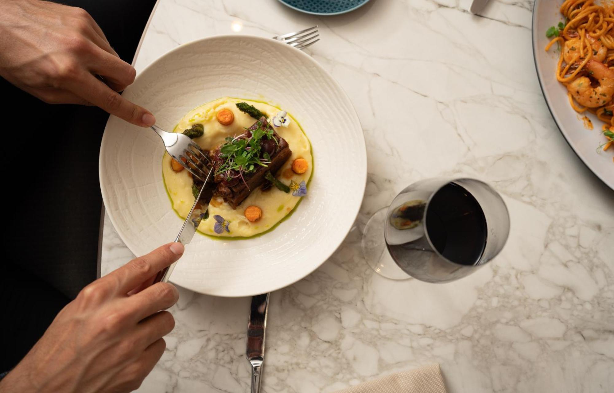 Hotel Address Estambul Exterior foto A person using a fork to cut into a meal
